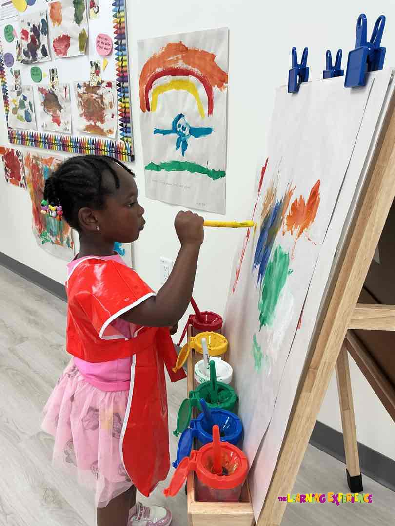 Child painting on an easel in a classroom