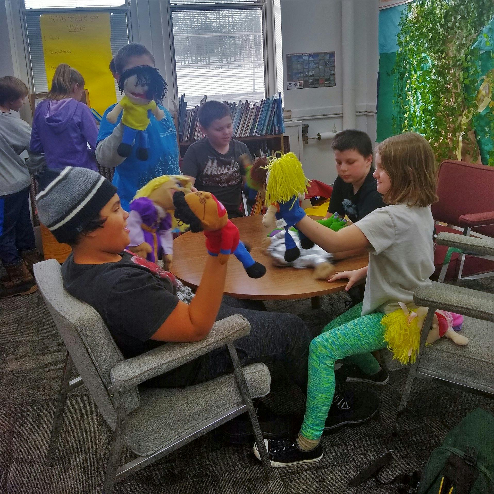 Children playing with puppets in a classroom