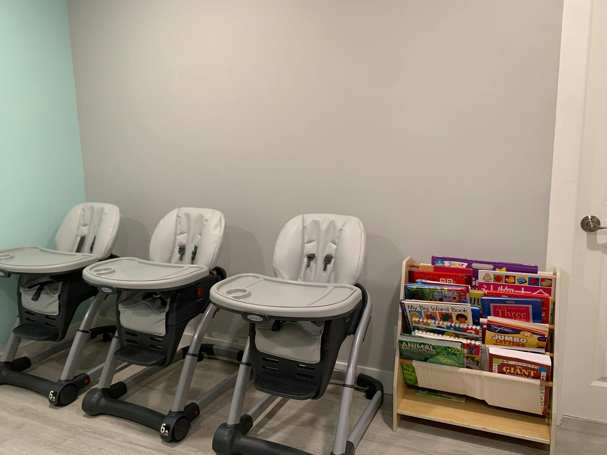 Three high chairs and a small bookshelf with books