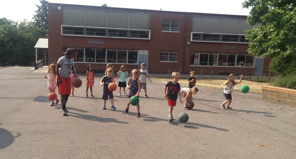 Adult and children playing with balls outdoors
