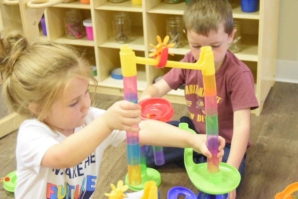 Two children playing with a colorful water toy