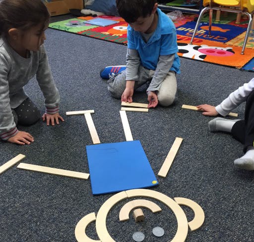 Children playing with wooden blocks on a carpeted floor