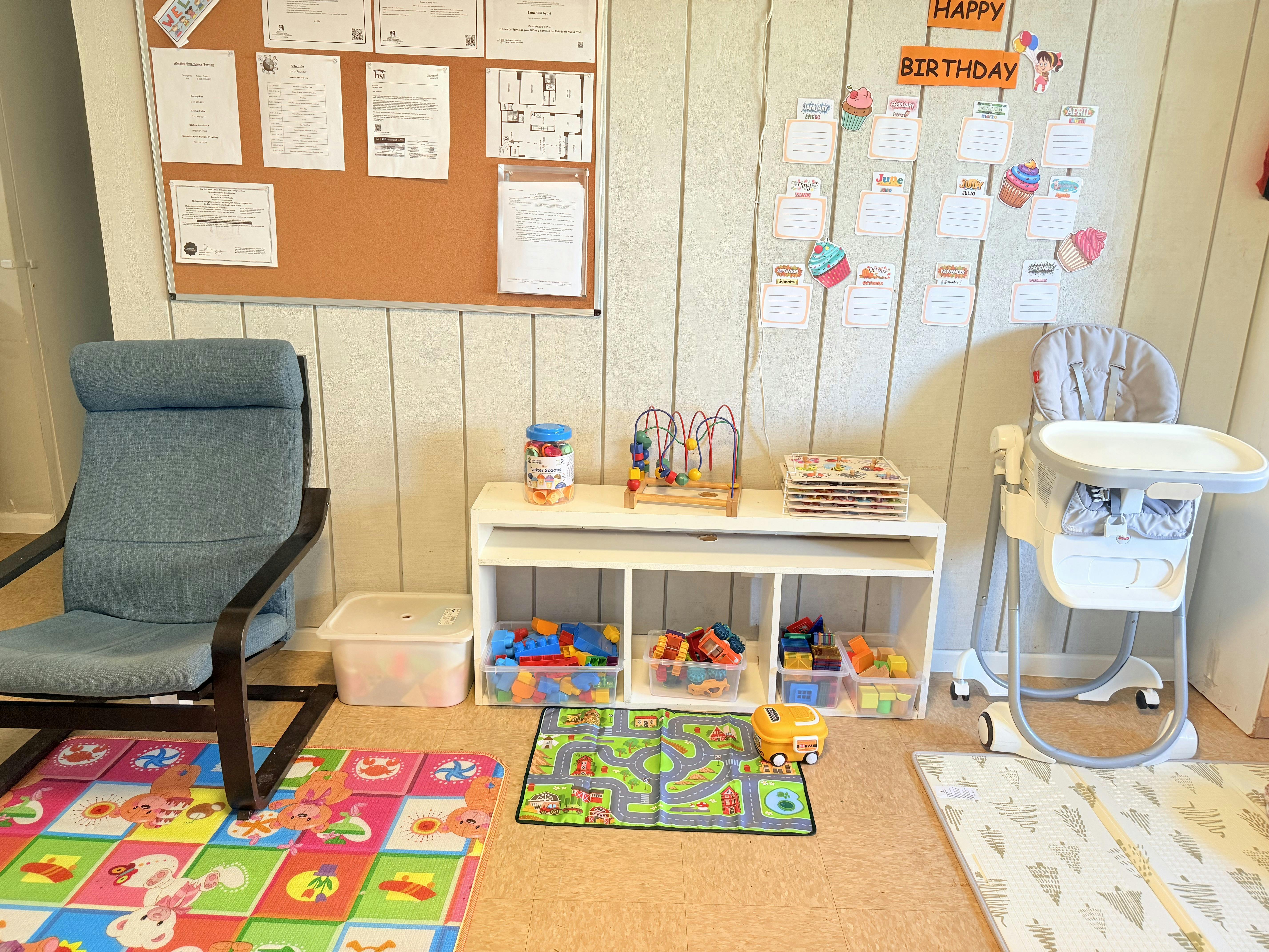 Child's play area with a high chair, toy storage, and colorful mats