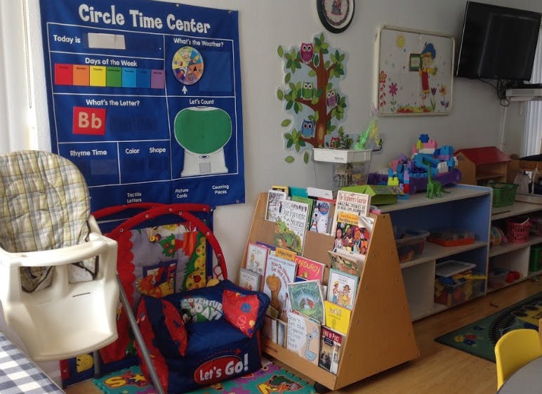 Classroom with a Circle Time Center chart, high chair, and book display