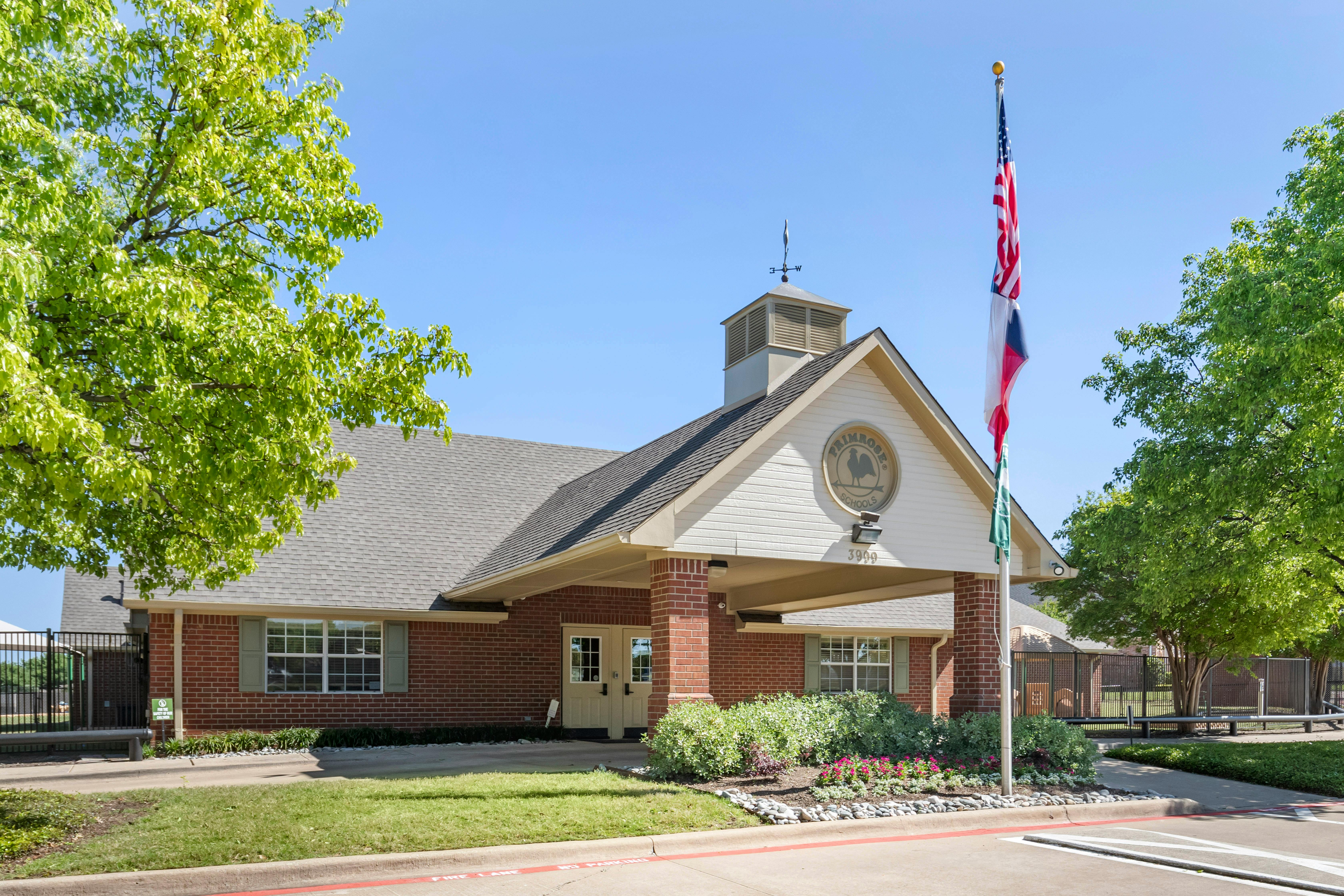 Brick building with a covered entrance and an American flag