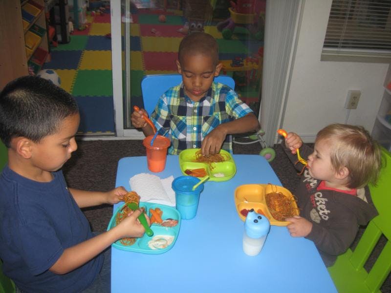 Three children eating at a table
