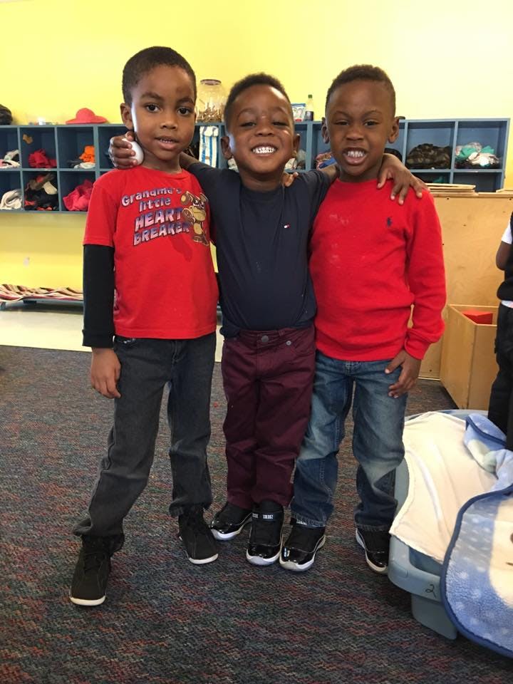 Three children standing with arms around each other