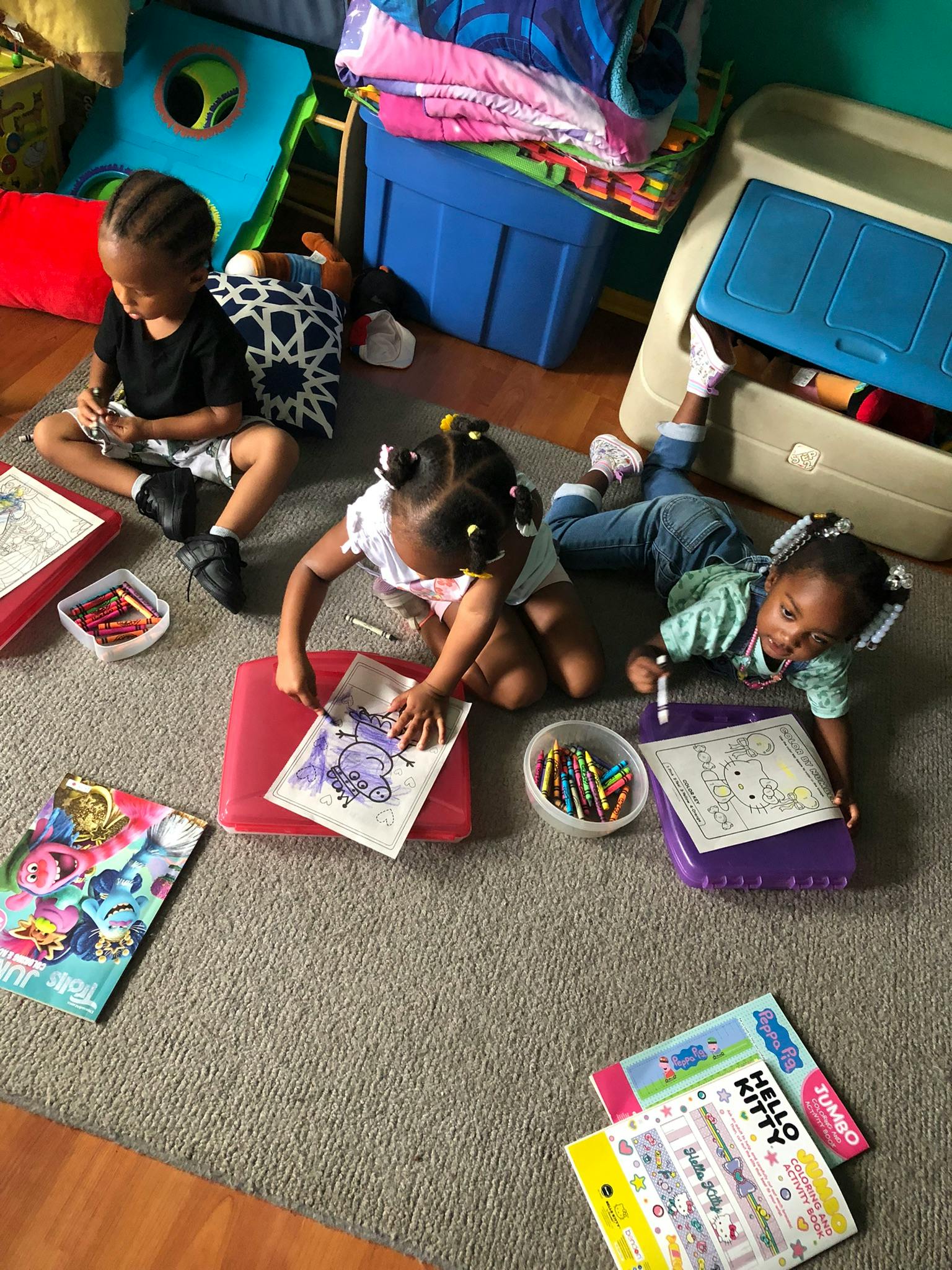 Three children coloring on the floor
