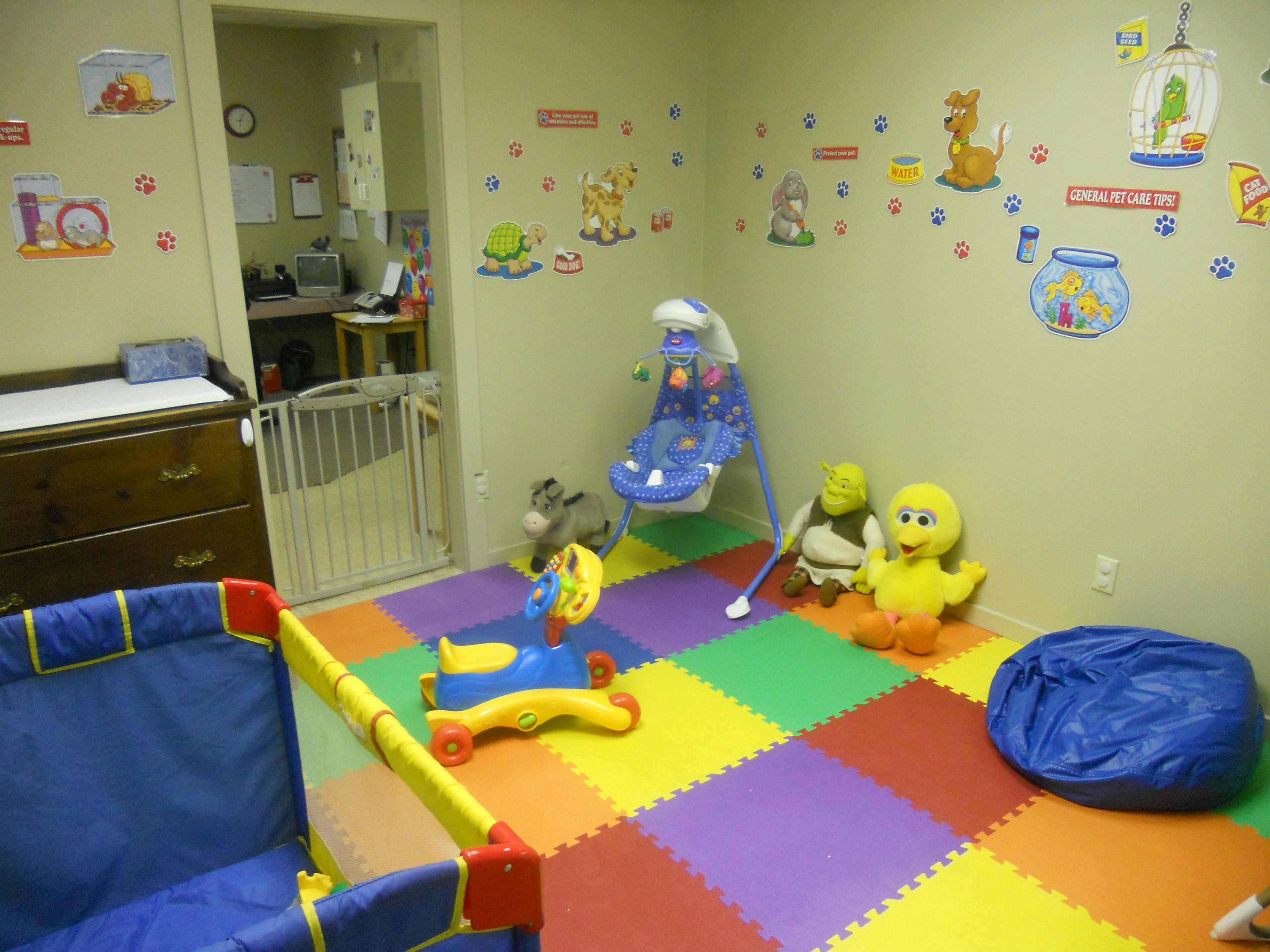 Playroom with colorful floor mats, toys, and wall decals