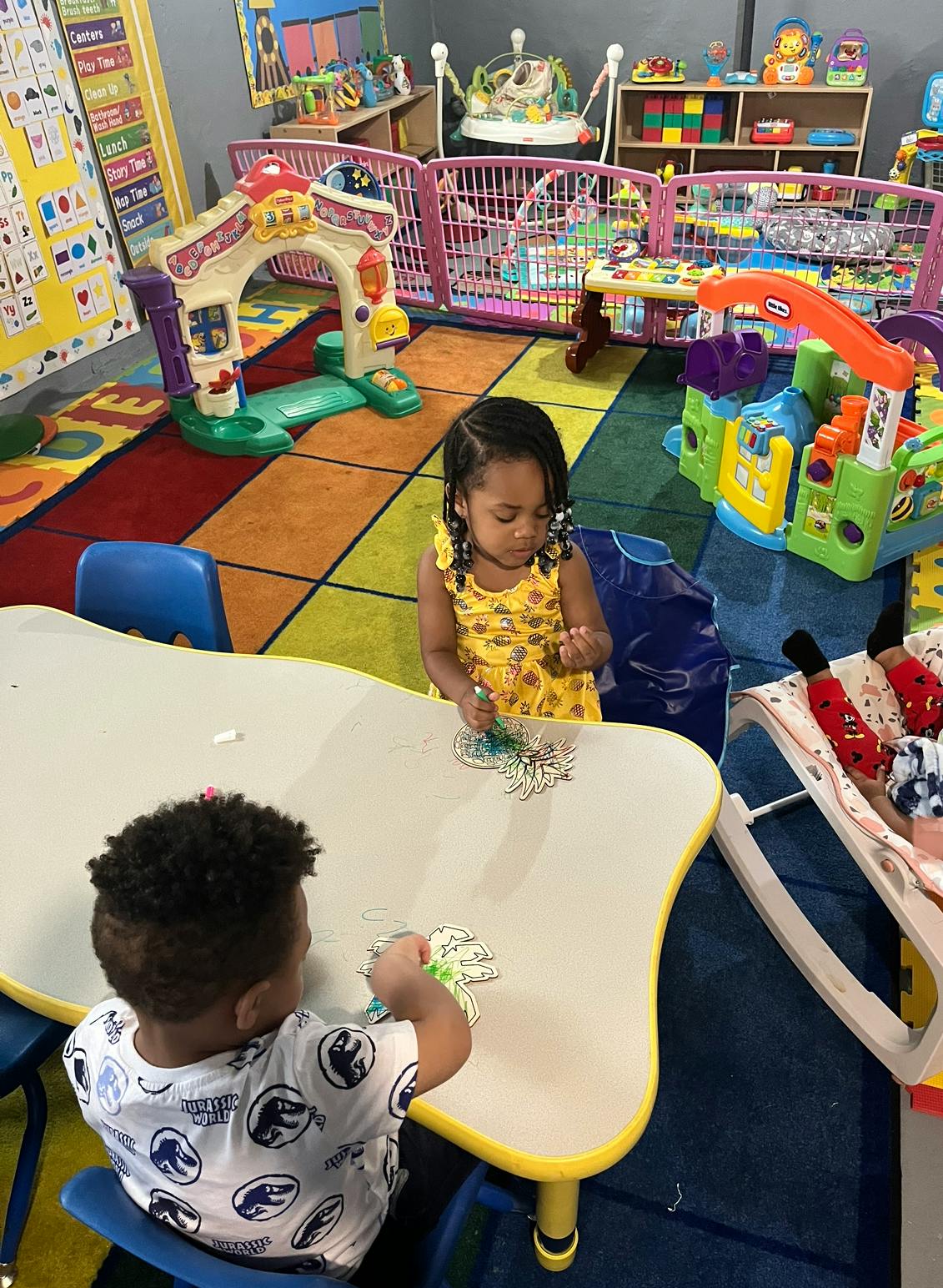 Two children playing at a table in a colorful room
