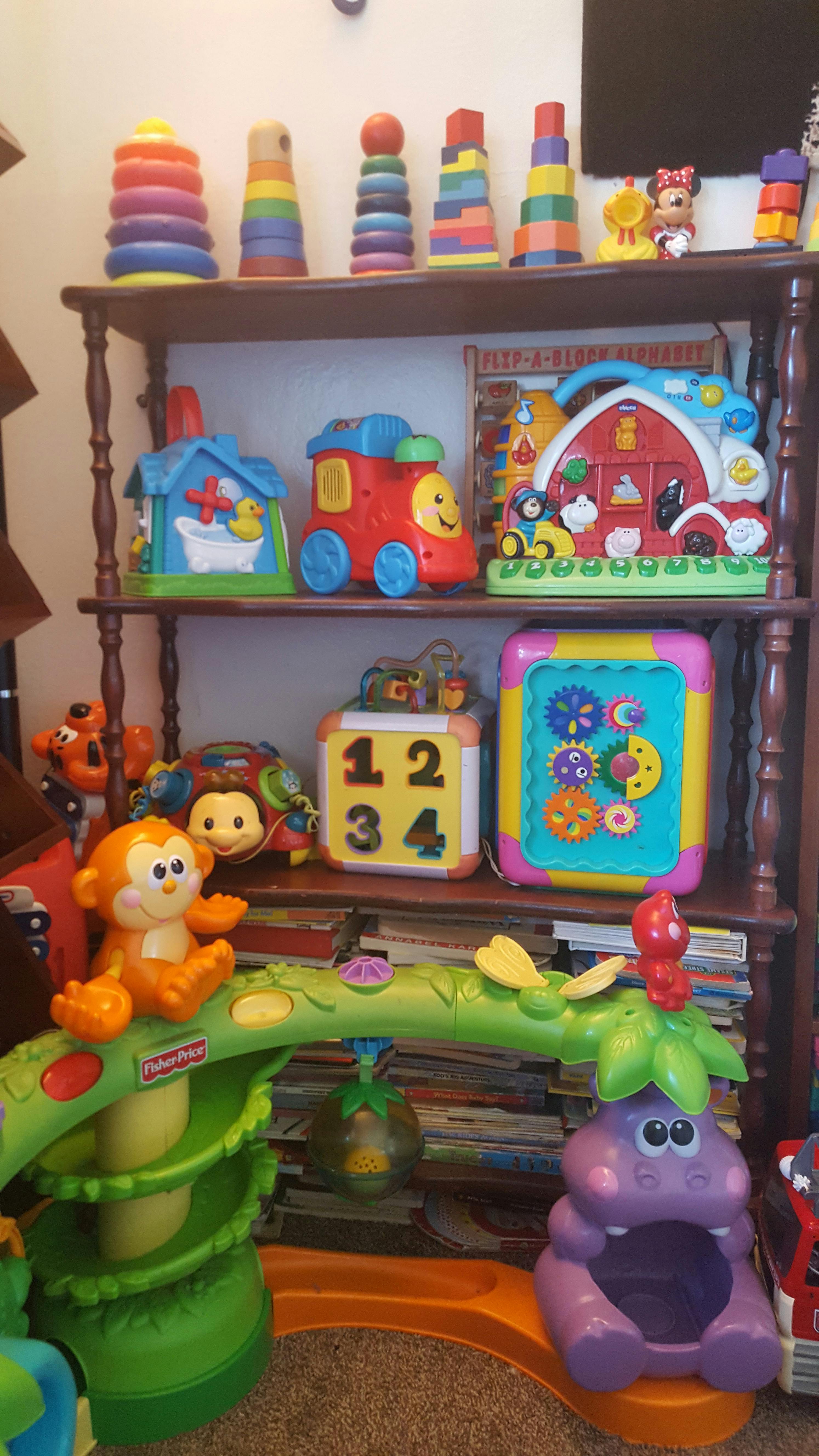 Shelf with various colorful children's toys, including stacking rings and a toy train