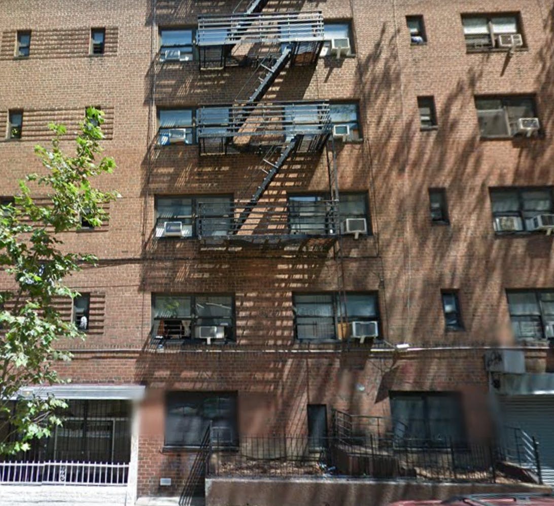 Brick building with fire escapes and multiple windows