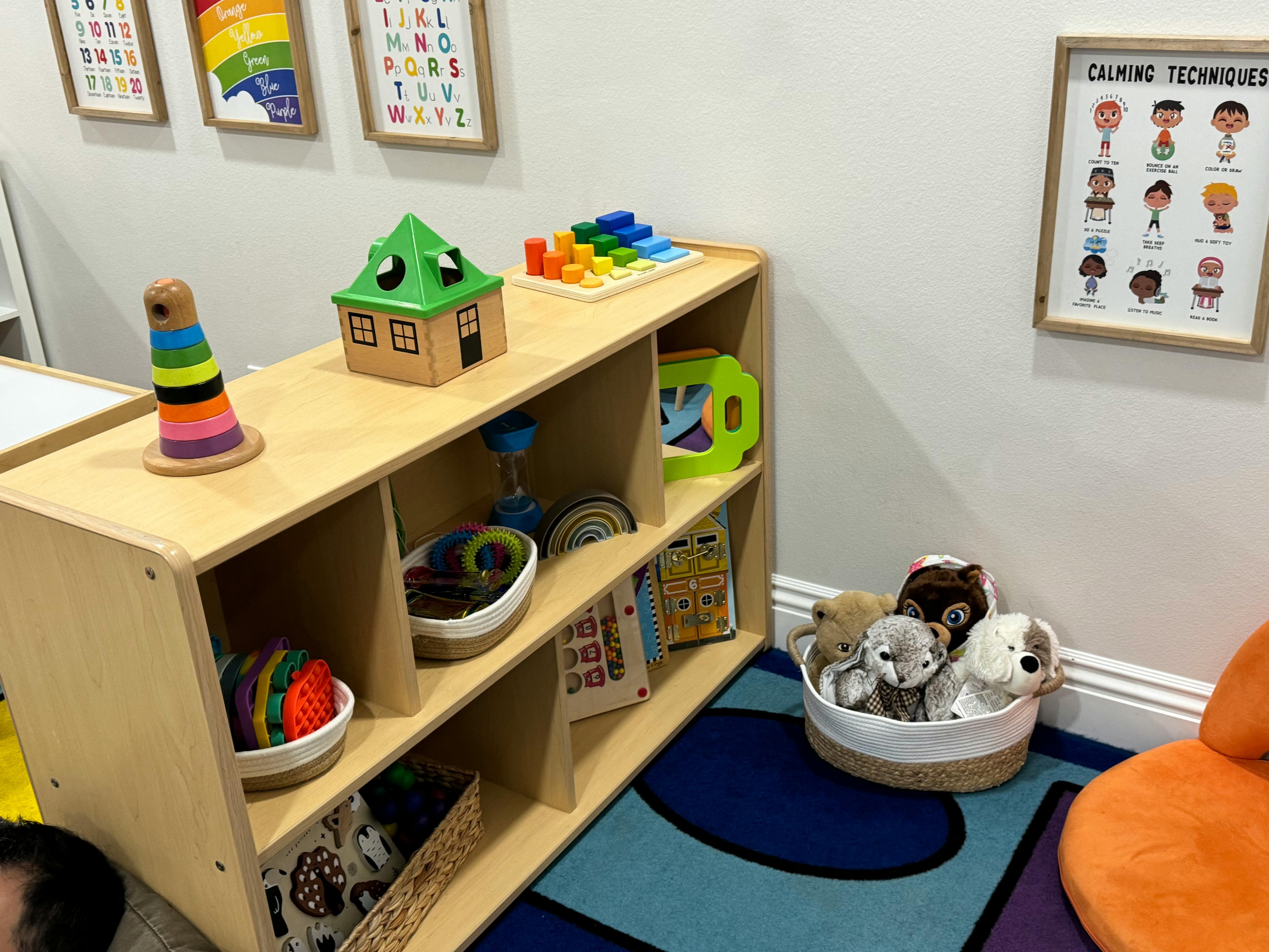 Wooden shelf with toys and books in a room