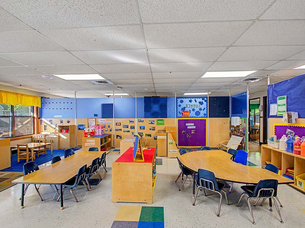 Empty classroom with tables, chairs, and colorful decorations