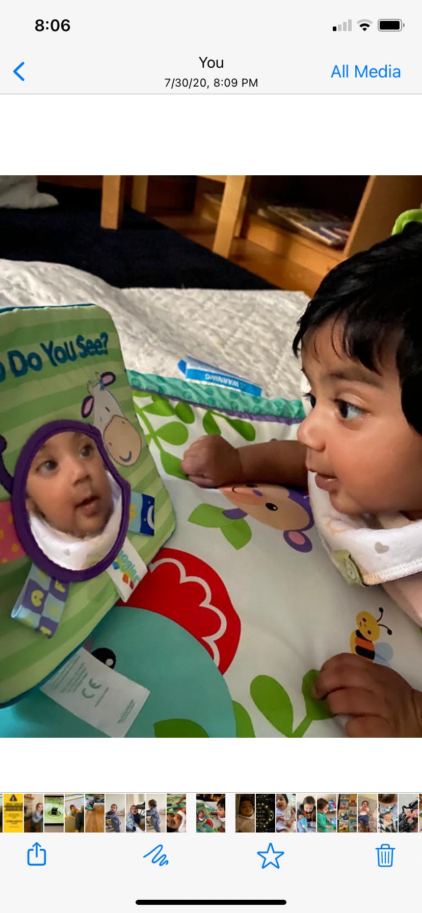 Child looking at their reflection in a mirror on a play mat