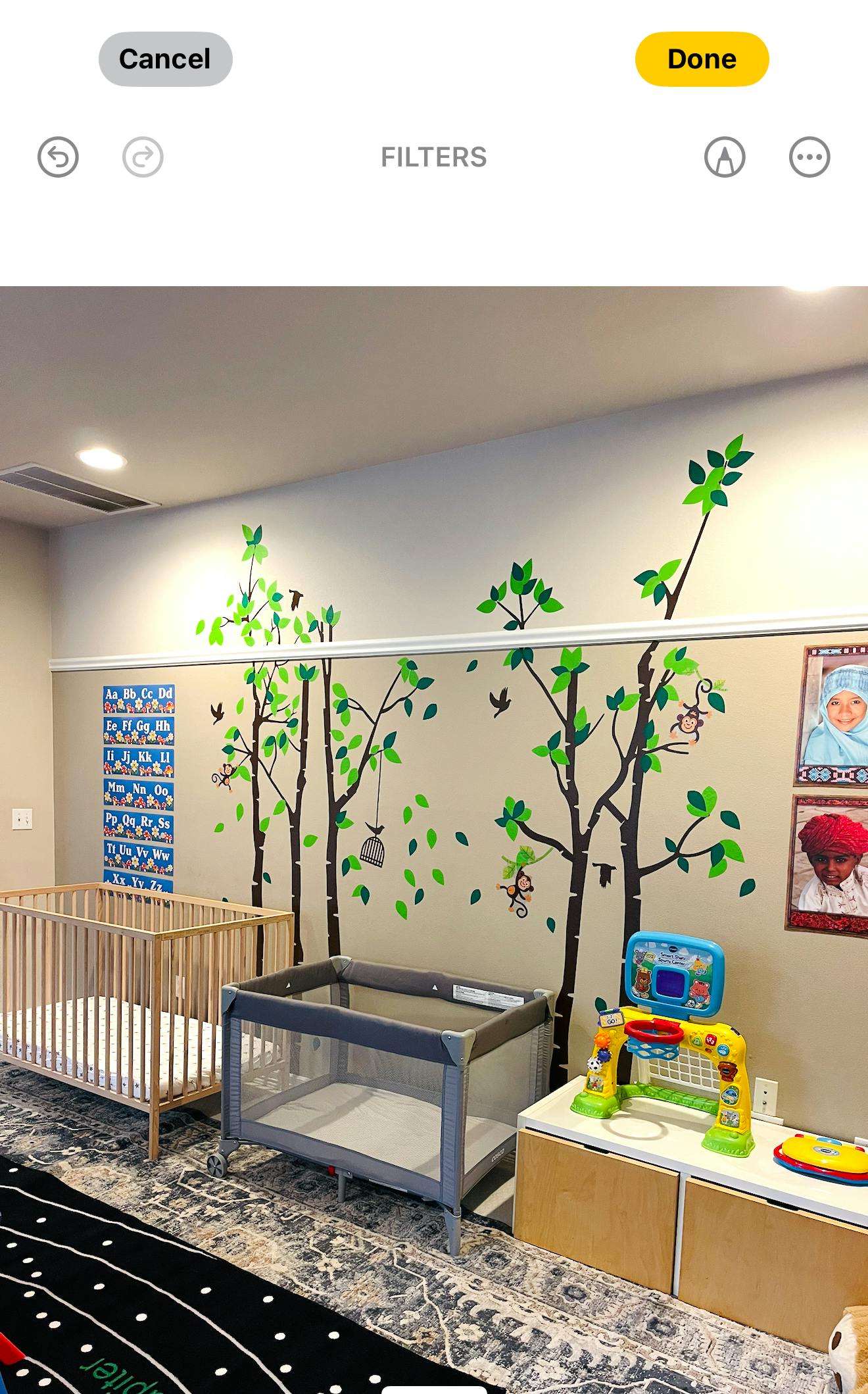 Nursery room with two cribs and tree wall decals