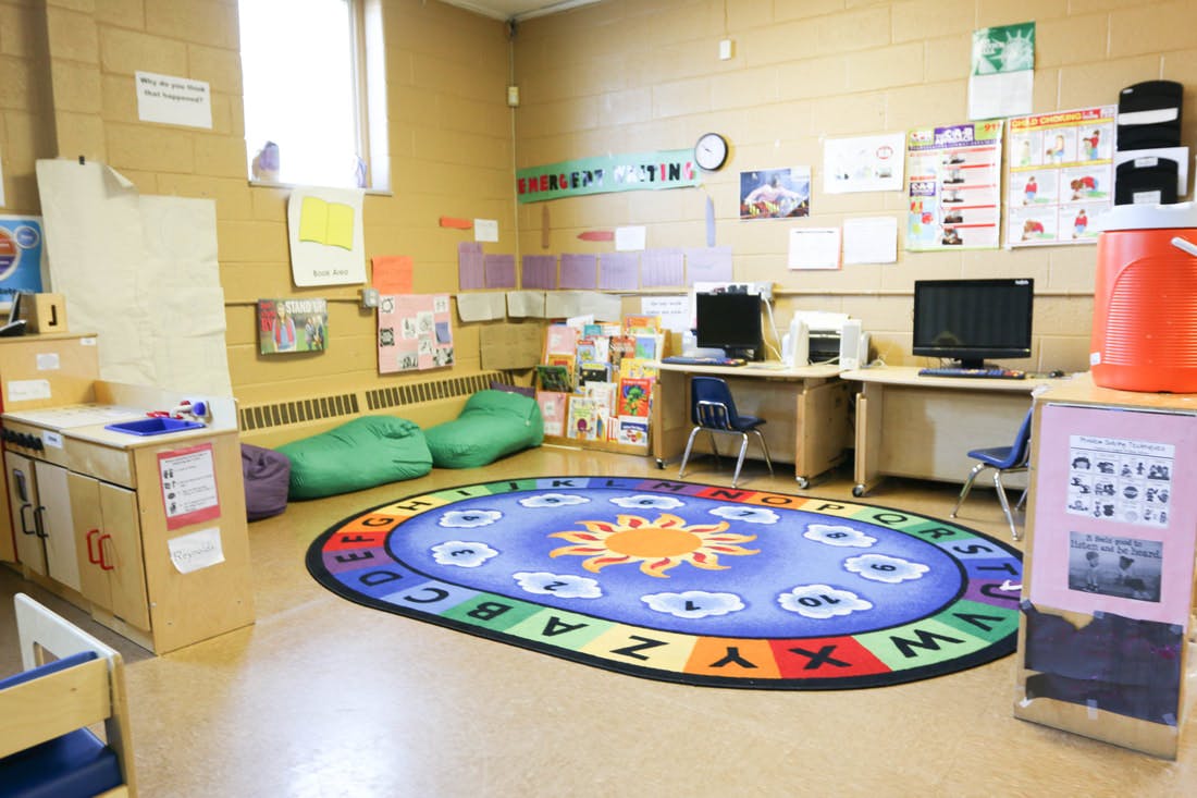Classroom with an alphabet rug, computers, and beanbag chairs