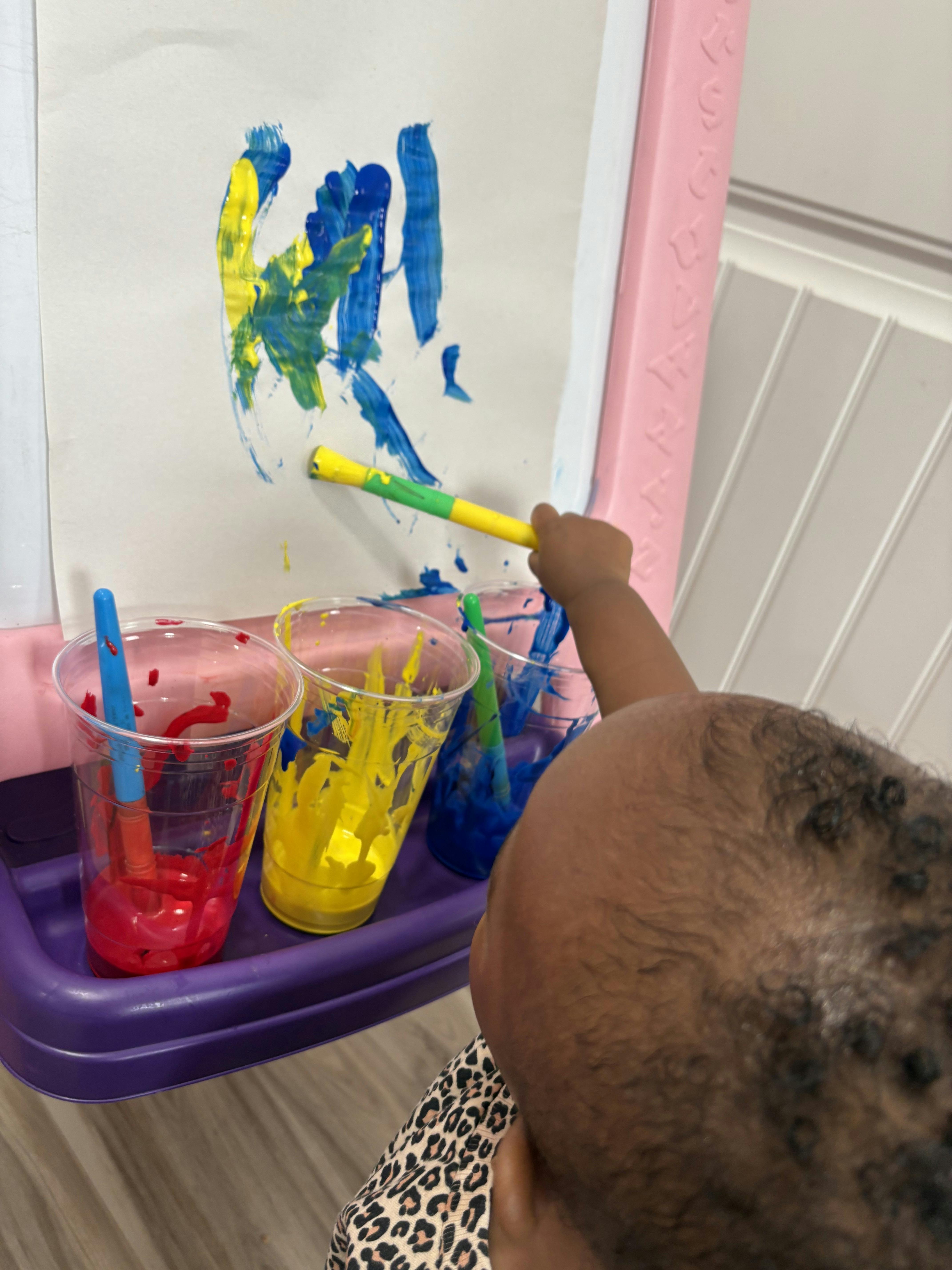 Child painting on an easel with a brush