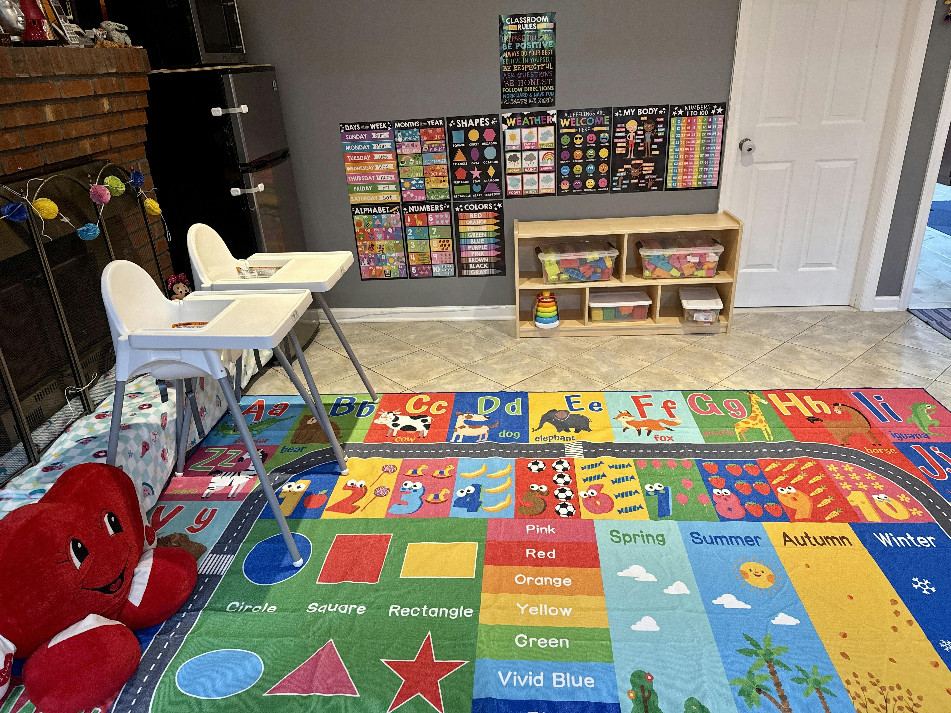 two white high chairs and a colorful learning rug with educational posters