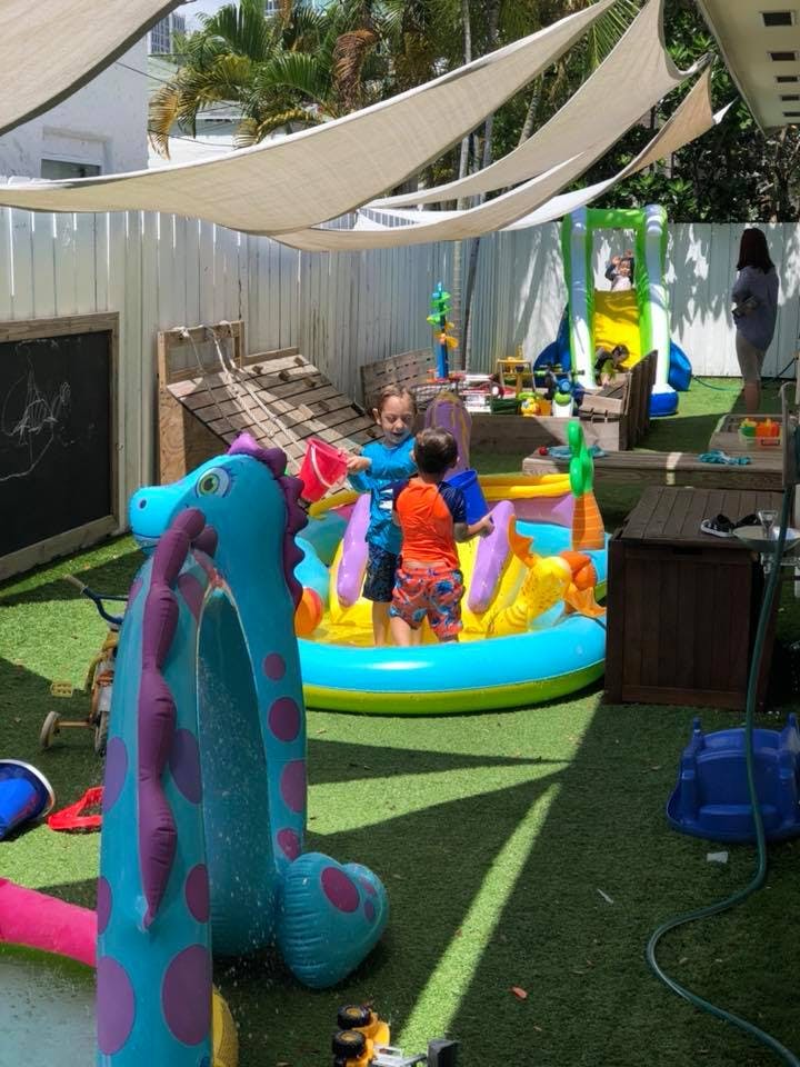 Two children playing in an inflatable pool with toys