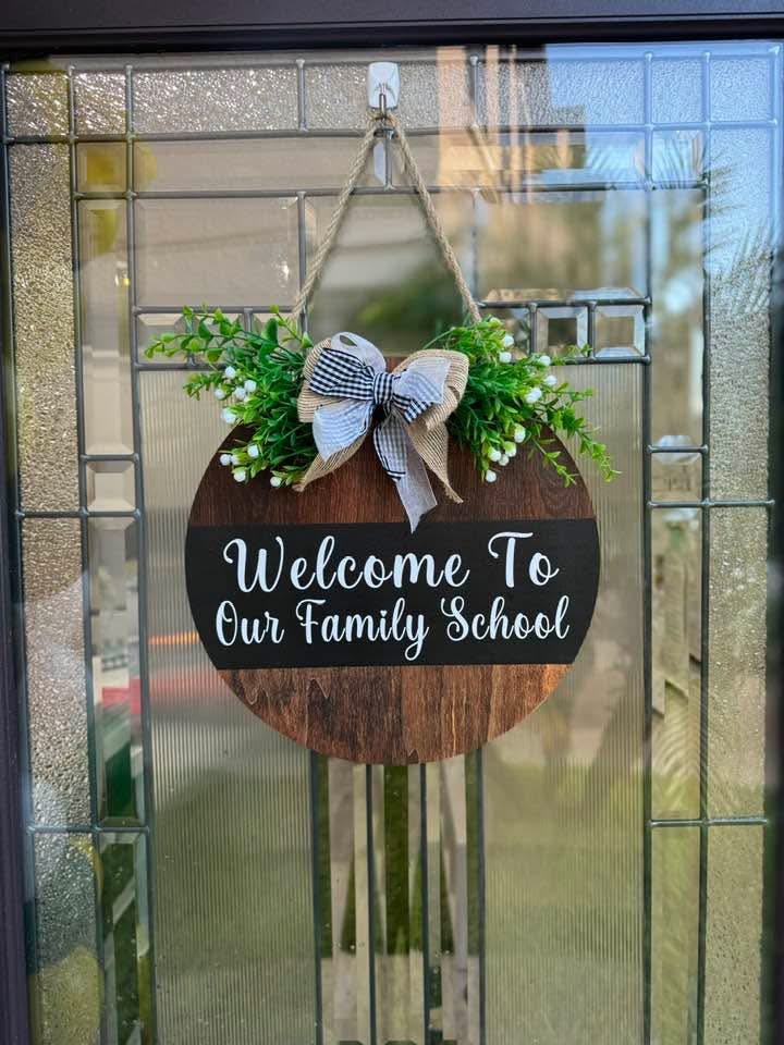 Wooden door sign with "Welcome To Our Family School"