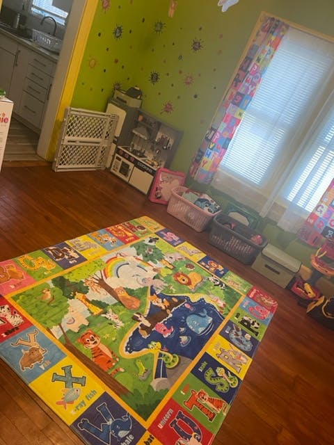 Playroom with a colorful alphabet and animal playmat on a wooden floor