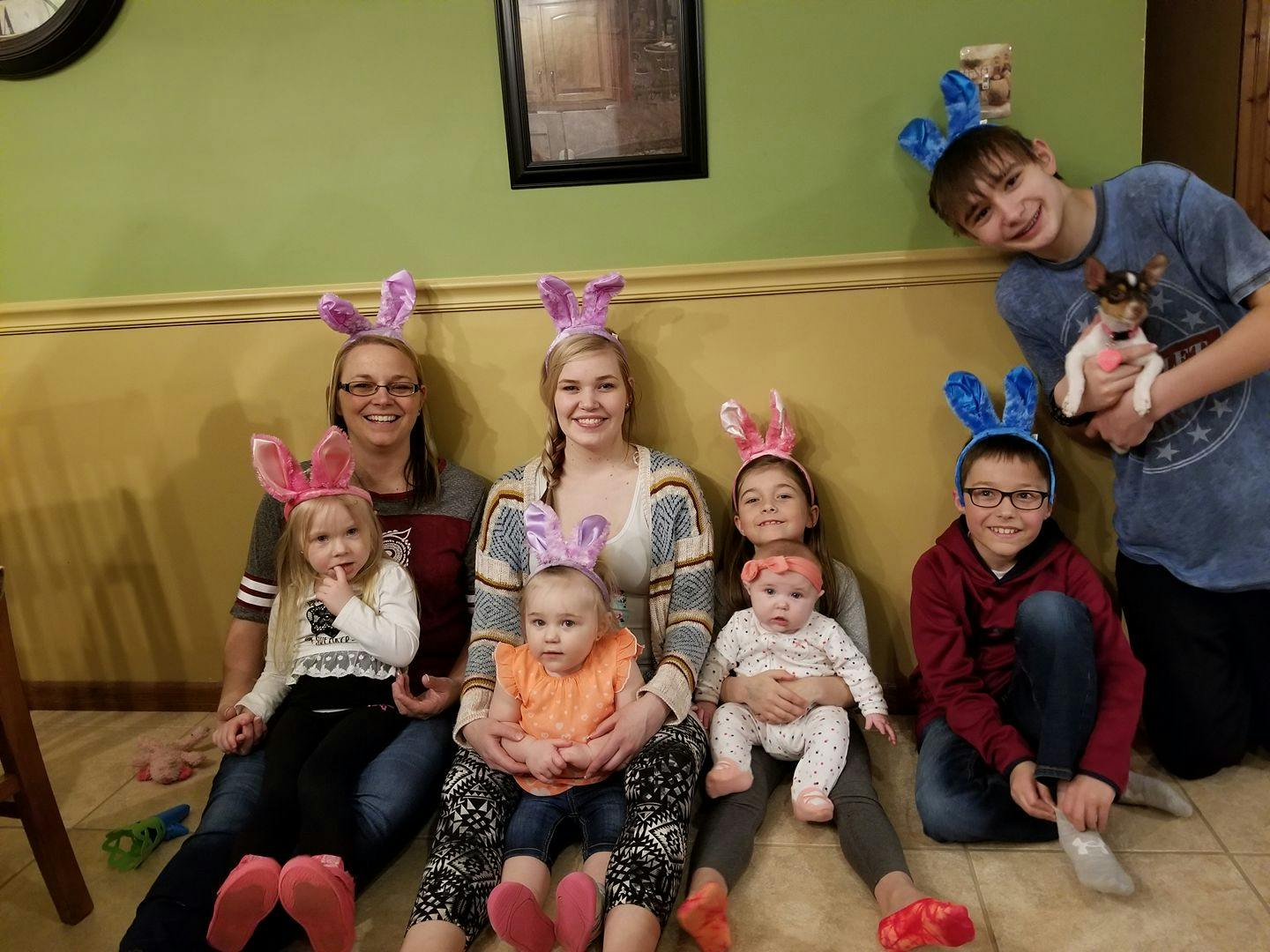Group of people and children wearing bunny ears, some holding babies