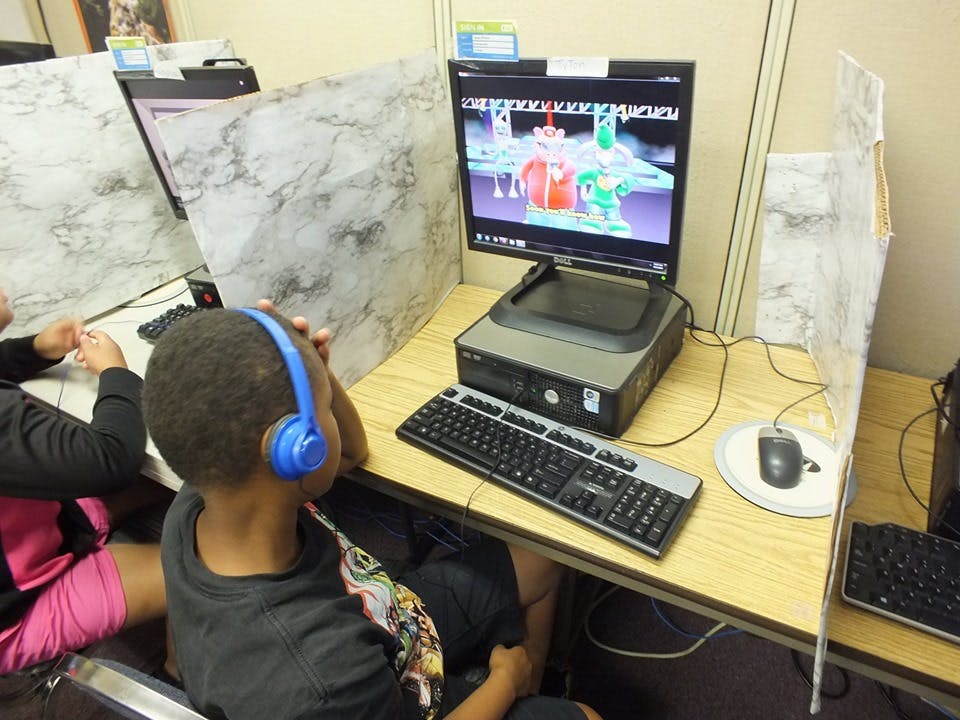 Child wearing headphones at a computer station