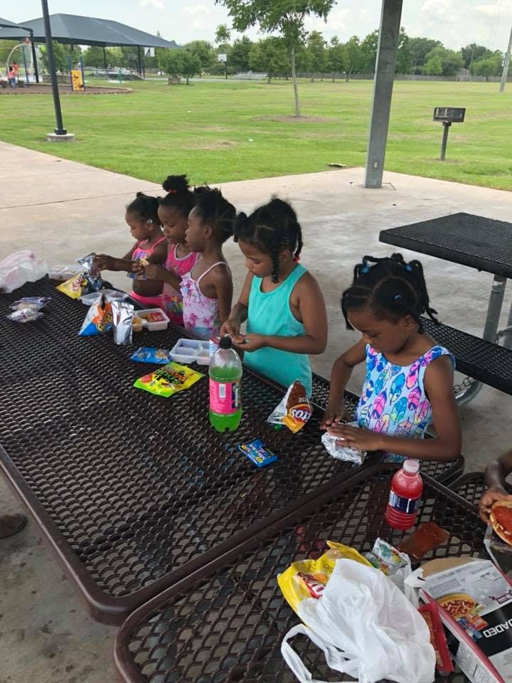 Children sitting at a picnic table with snacks