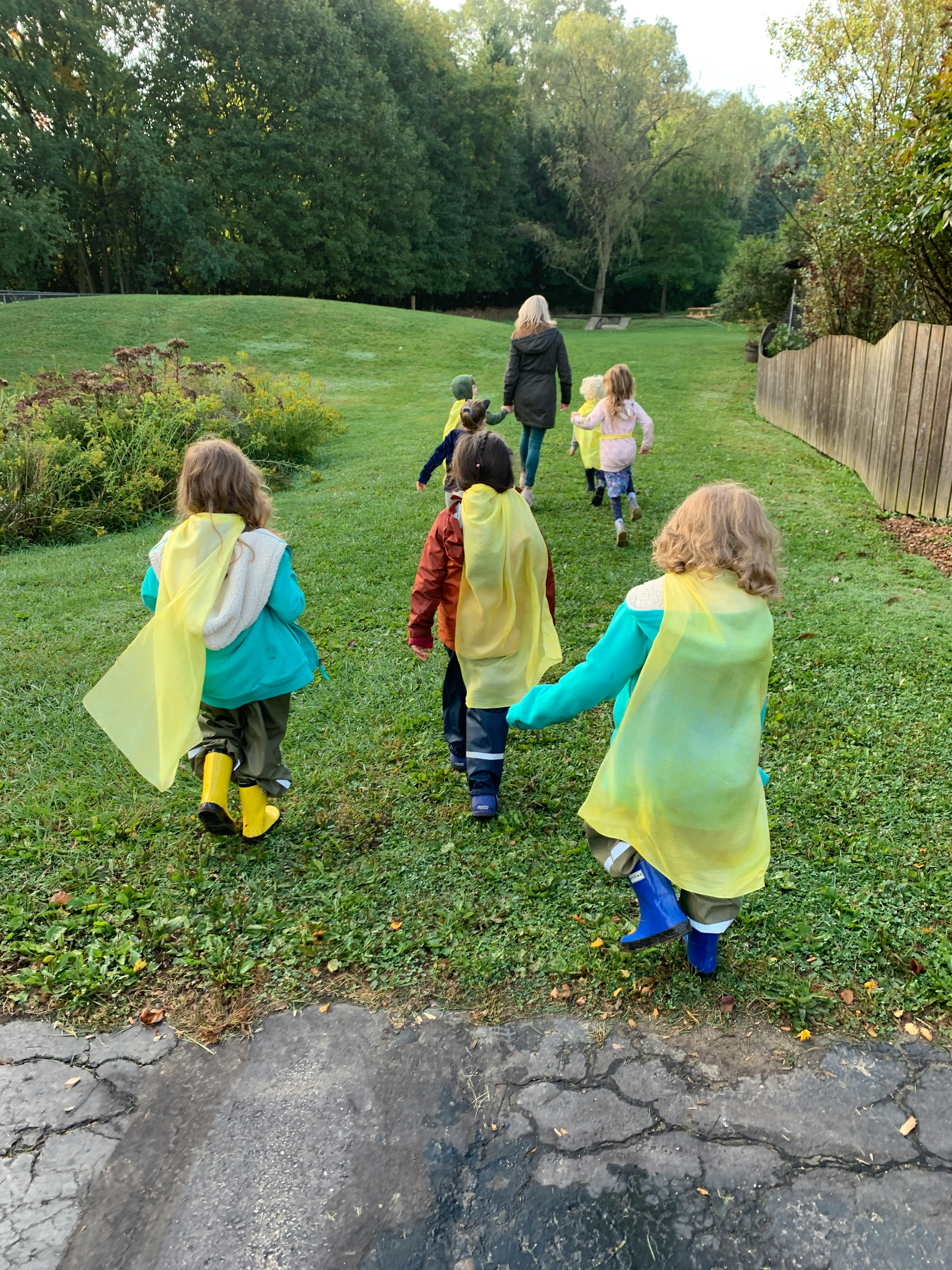 Children and an adult walking on a grassy path