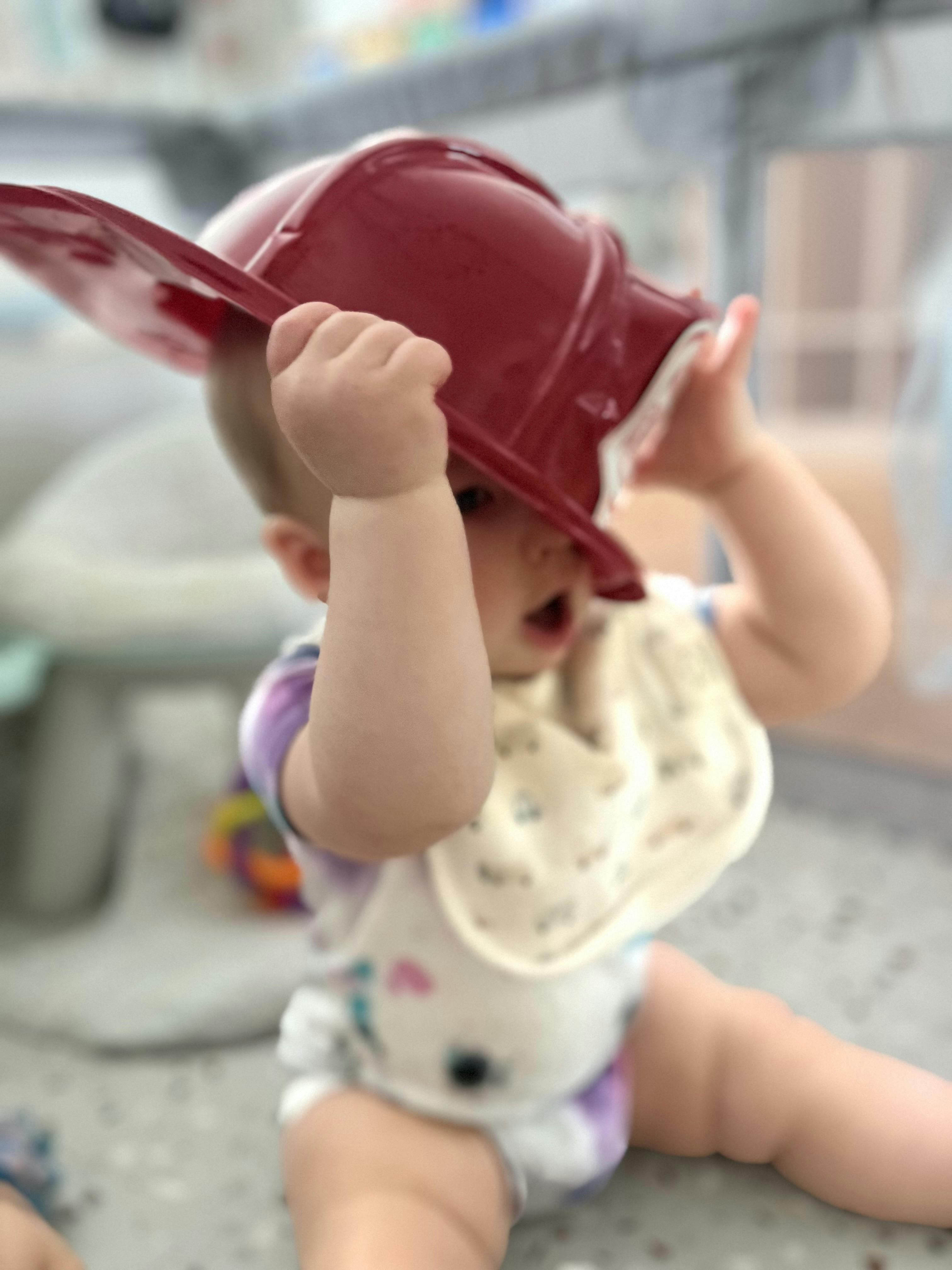 Child wearing a toy red helmet