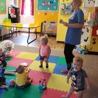 Adult and multiple children in a colorful room
