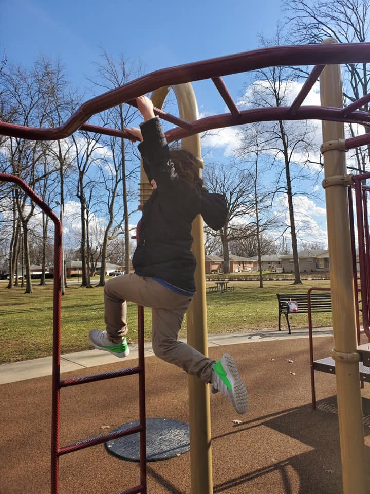 Child on monkey bars at a playground