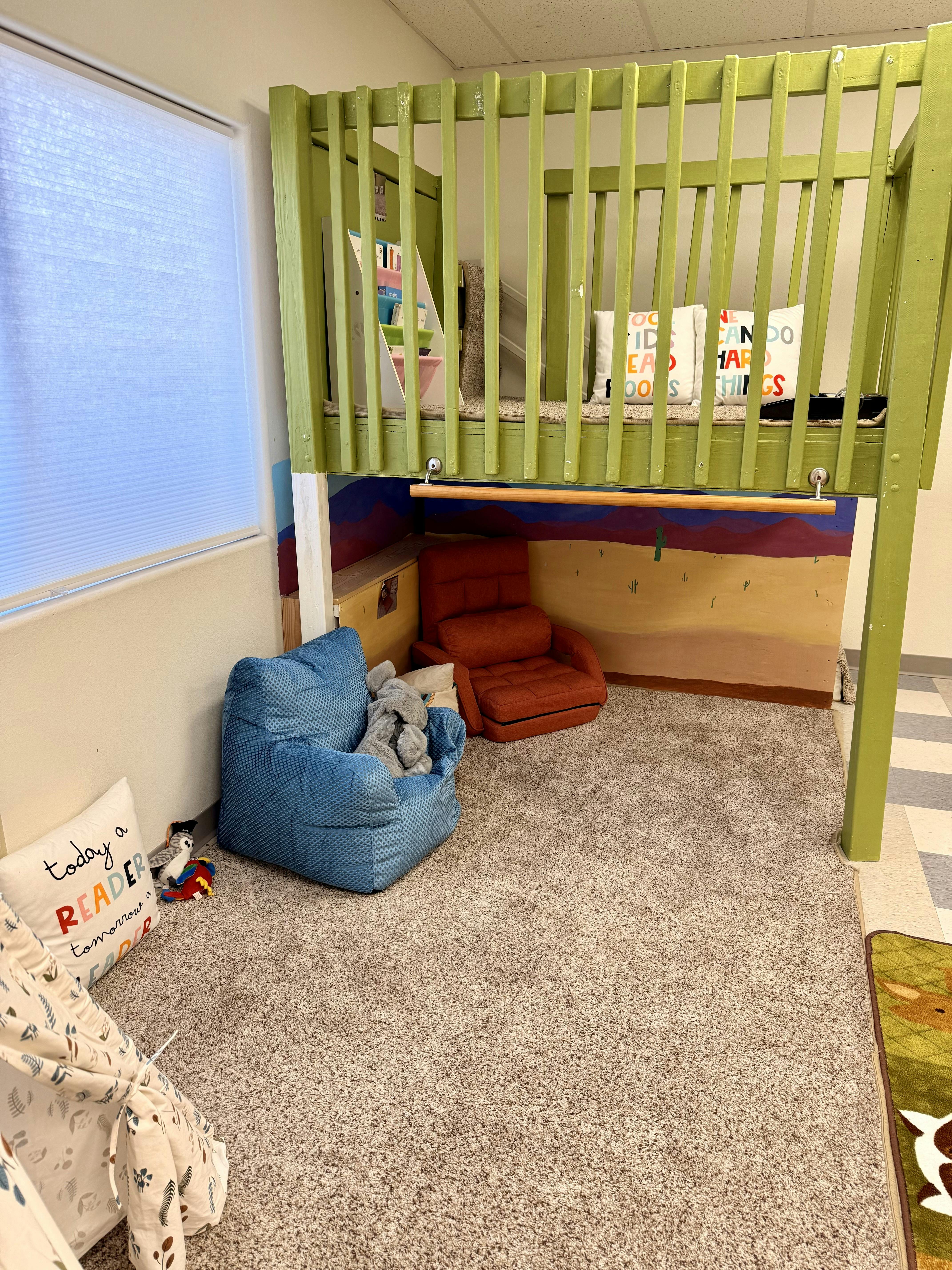 Children's room with a green loft bed, blue bean bag chair, and red armchair