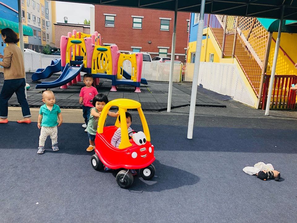 Children playing with a toy car on a playground