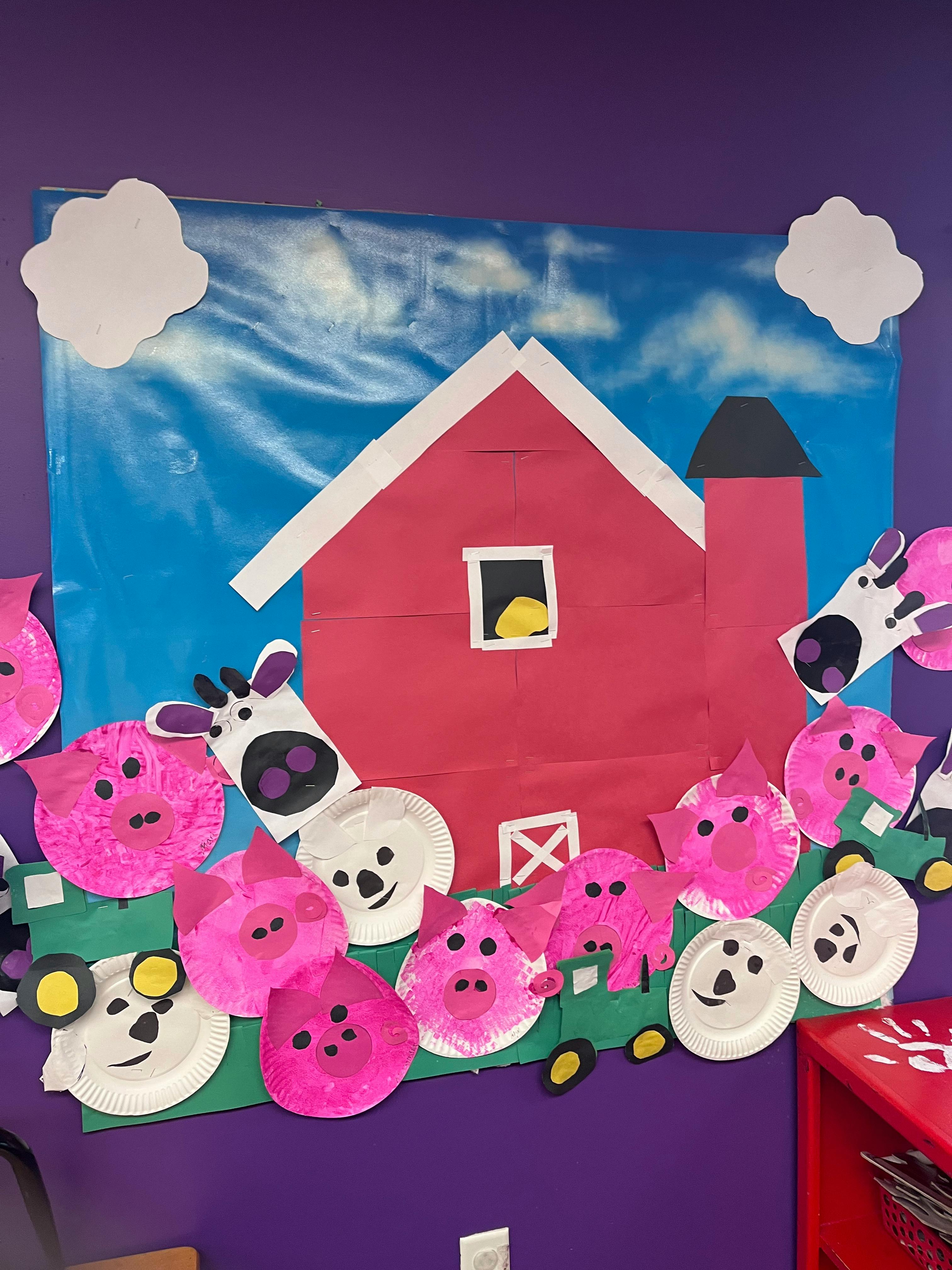 Paper craft of a red barn with paper plate farm animals