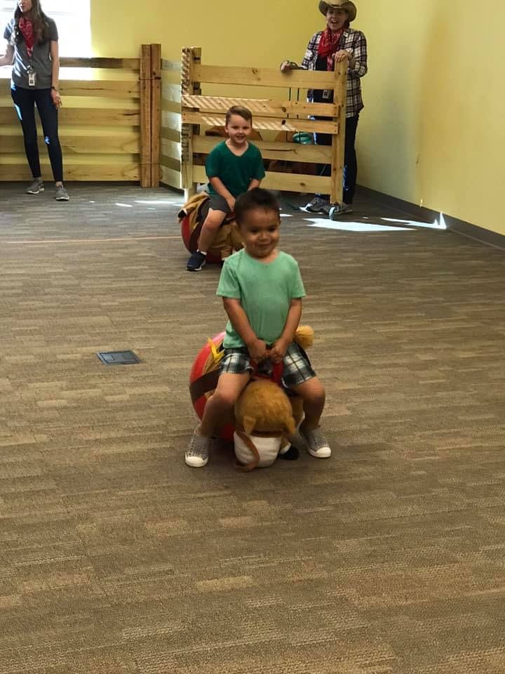 Two children riding toy horses indoors