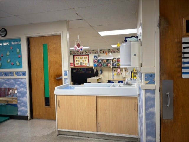 Classroom sink area with a soap dispenser on the wall