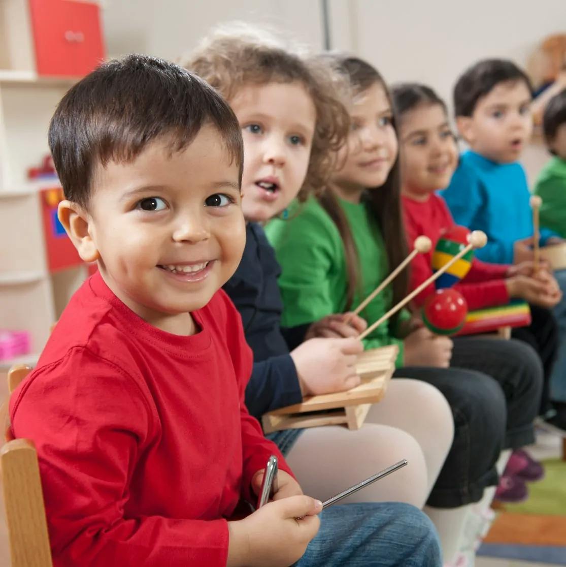Children playing musical instruments in a classroom
