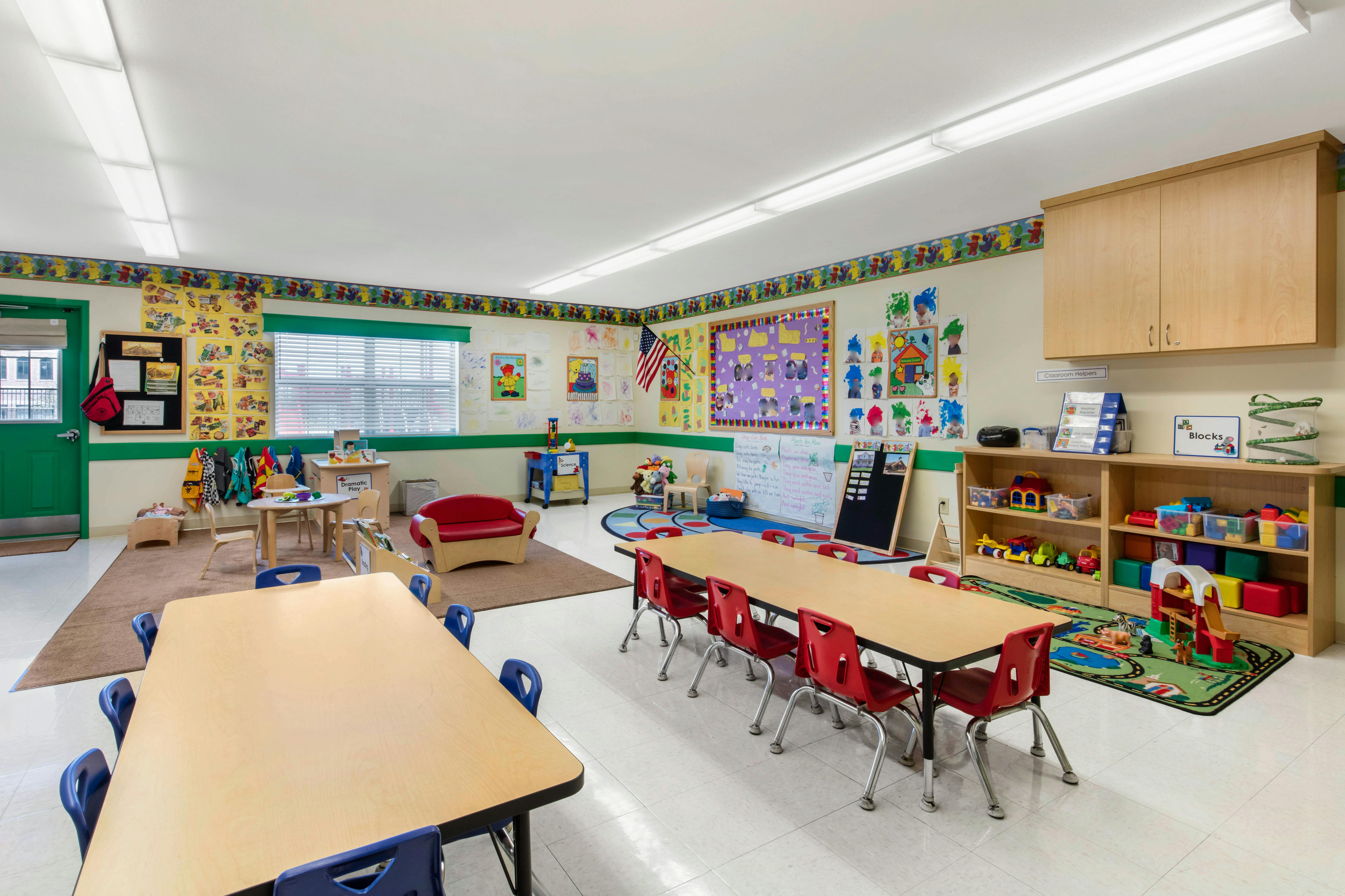 Classroom with tables, chairs, toys, and decorated walls