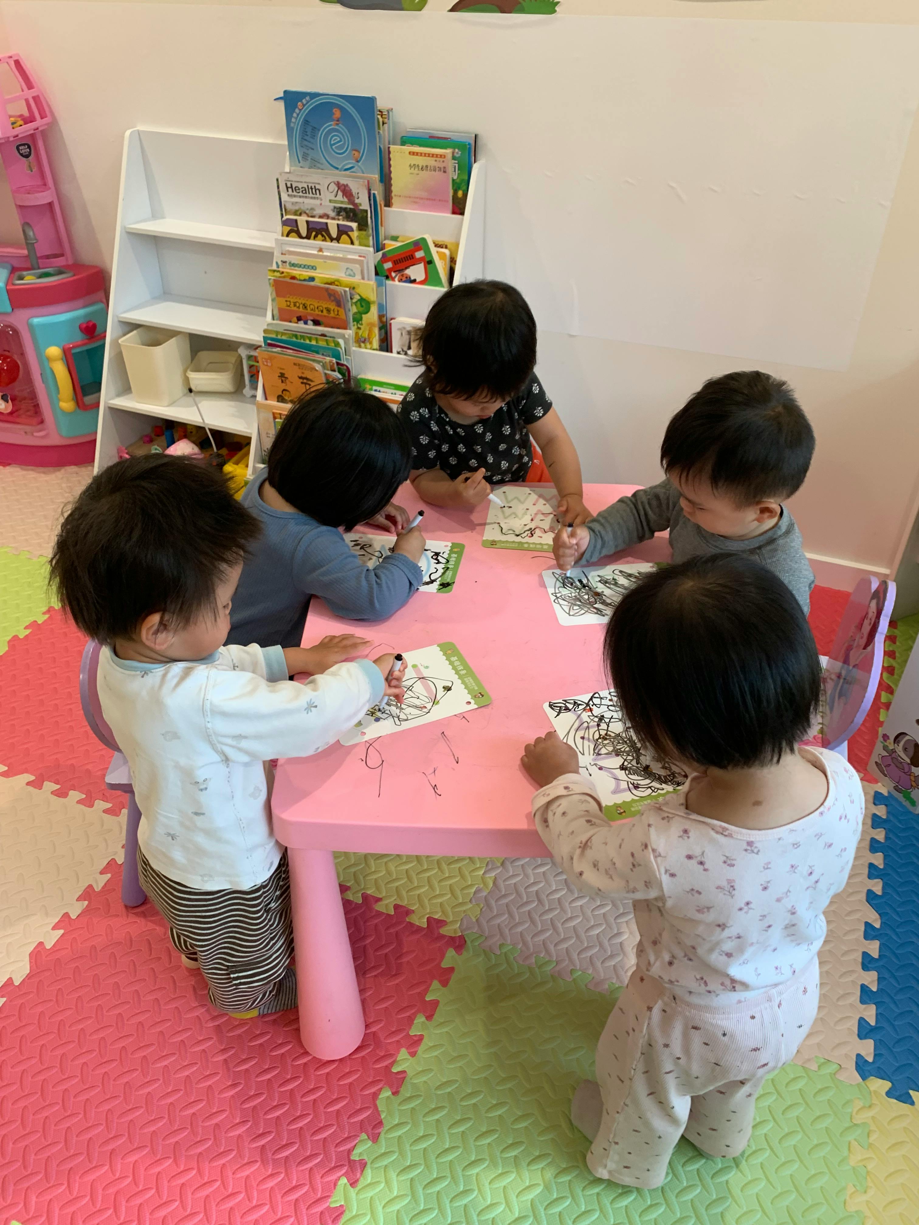 Group of children drawing with markers at a table
