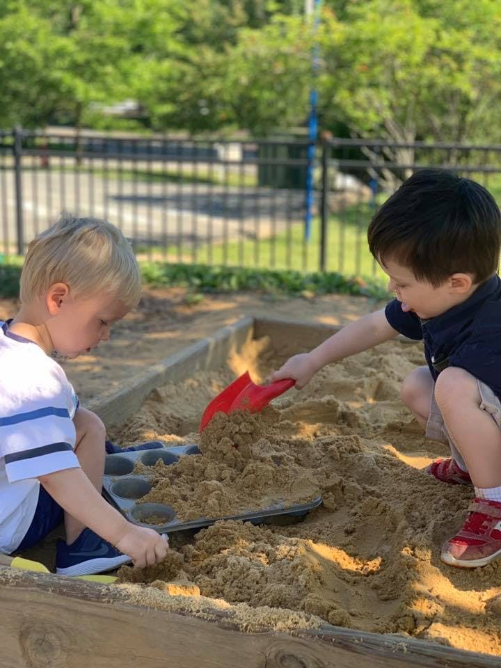 Two children playing in a sandbox