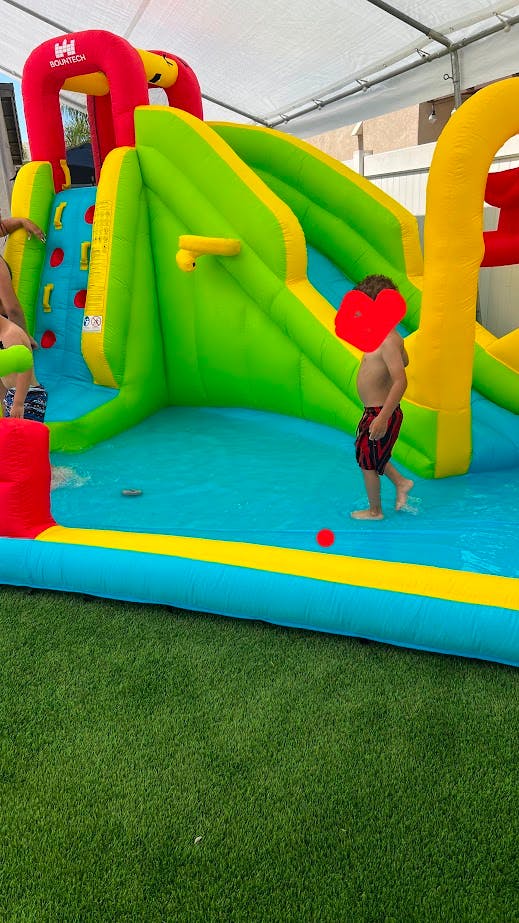 Child standing in water on an inflatable slide