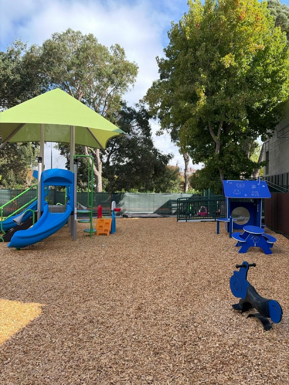 Playground with climbing structure, slide, and small picnic table