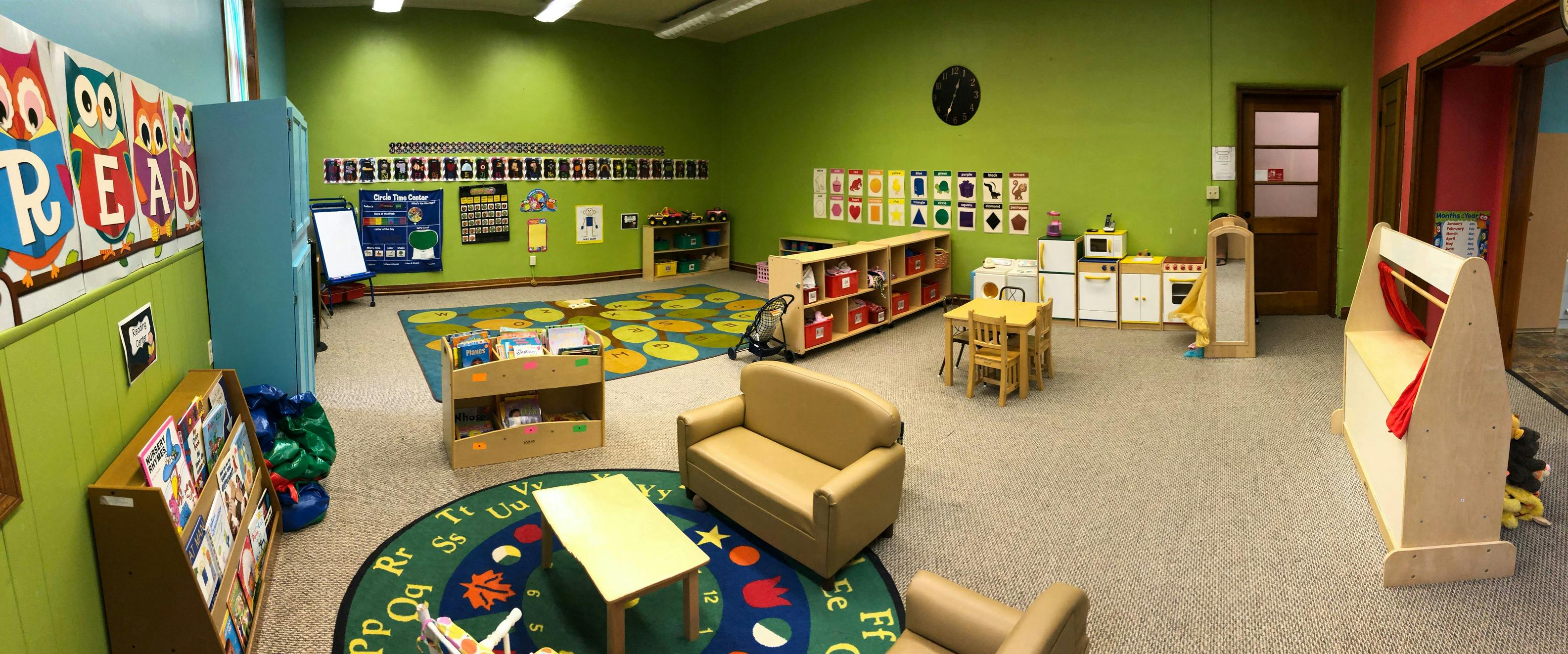 Empty classroom with small furniture and colorful rugs
