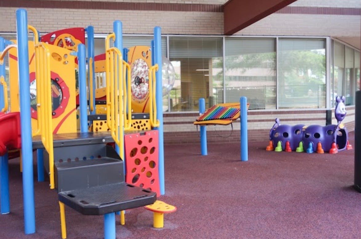 Colorful playground equipment including a climbing structure and tunnel