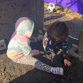 Two children playing in dirt