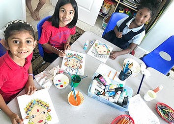 Three children painting at a table