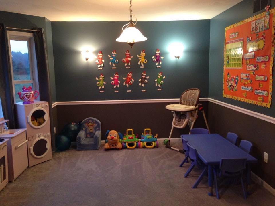 Playroom with toys, small table and chairs, and wall decorations