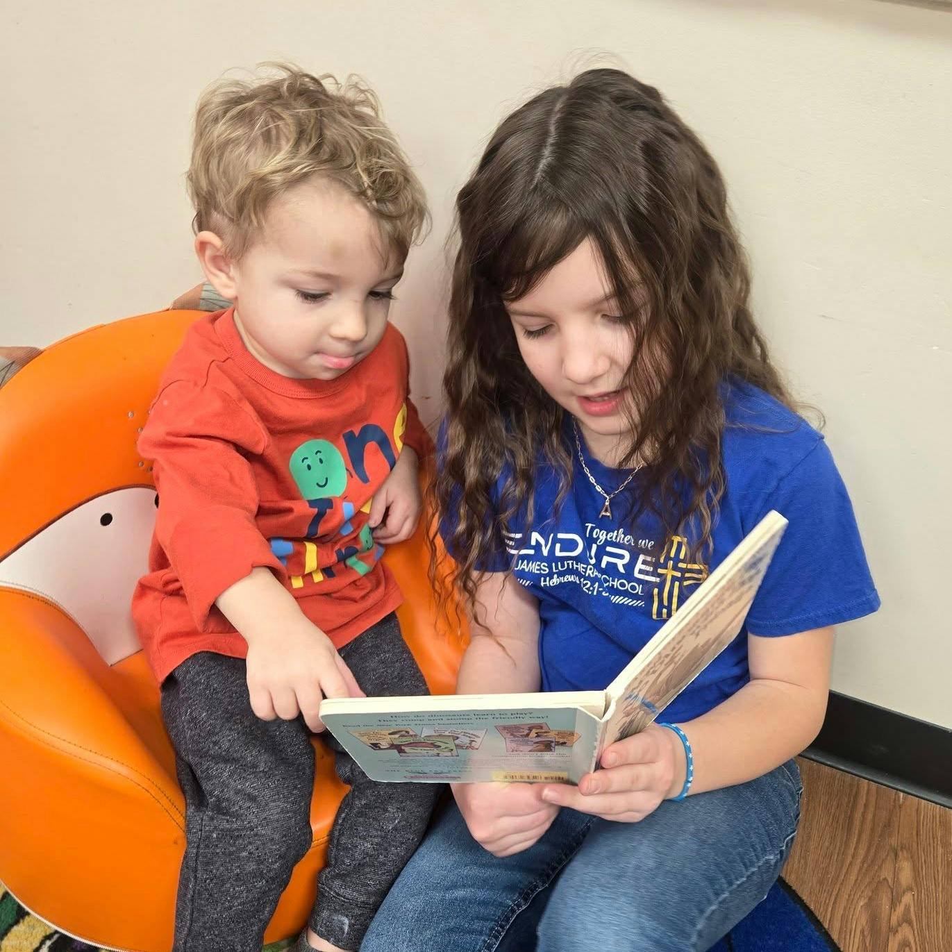 Child and a teen reading a book together
